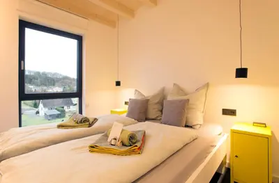 Ein Bett oder Betten in einem Zimmer der Unterkunft Modernes, ökologisches Design Ferienhaus in der Eifel Vulkaneifel I 2 Schlafzimmer, Sauna, Yoga & Kaminofen, schnelles WLAN & Arbeitsplatz
